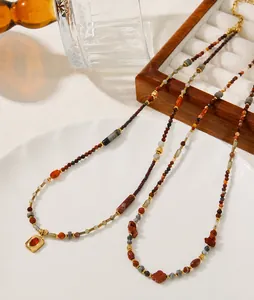 Détail d'un collier vintage avec pierres naturelles rouges et pendentif doré