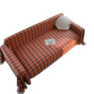 Classic rust red plaid sofa throw cover with grey fringe tassels on white sofa