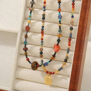 Detail of bohemian handmade beaded necklaces with red agate and turquoise on jewelry stand