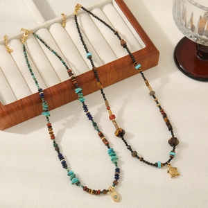 Detail of bohemian beaded necklaces with turquoise stones, turtle and sun pendants