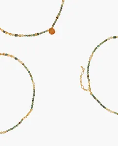 Detailed close-up of handmade beaded necklace featuring red agate and African pine stone