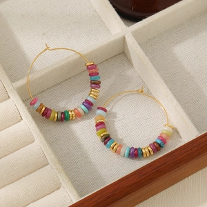 Detail of colorful tiger eye agate beads and golden spacers on hoop earrings