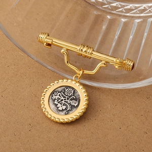 Close-up of vintage relief brooch with golden rope edge and silver bird engraving