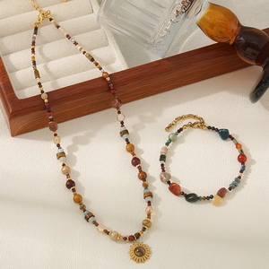 Detailaufnahme der Tigerauge-Halskette mit goldenem Sonnenanhänger und Armbandset