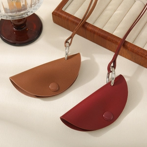 Dettaglio delle borse a mezzaluna in pelle PU con grana litchi nei colori marrone e bordeaux
