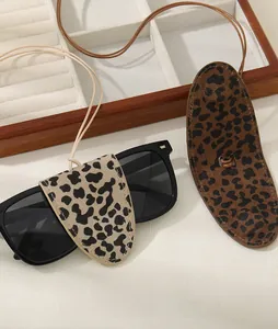 Detail view of leopard print leather sunglass cases with elegant neck lanyards for women