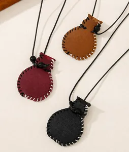 Detail of handmade leather drawstring pouch pendants in brown, burgundy, and black colors