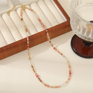 Detalle del collar de cuentas de colores con piedras rosas y cierre dorado ajustable