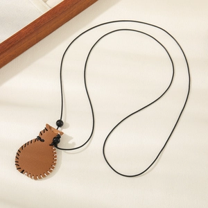 Artistic leather pouch pendant necklace with hand-stitched details on beige texture