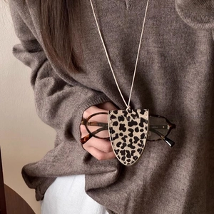 Leopard print leather eyewear holder necklace shown on a brown knit sweater detail