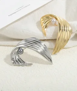 Detail of vintage wing brooches in gold and silver finish with elegant pearl accents