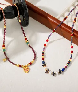 Close-up of garnet beads with golden butterfly pendant and delicate pearl detailing