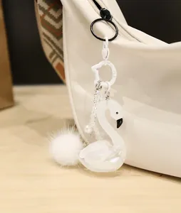 Detailansicht eines weißen Schwan-Schlüsselanhängers mit Plüschkugel und Perle an Tasche