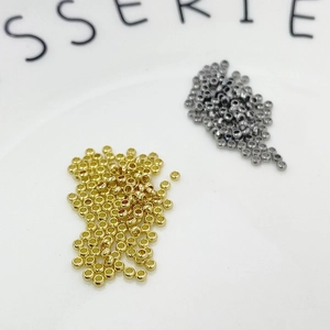 Detailed view of 2mm gold and gun-black spacer beads for DIY jewelry making