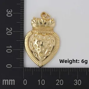 Macro shot of gold Sacred Heart pendant with textured relief on measurement mat