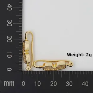 Makro-Detail von vergoldeten Brillenohrringen mit Zirkonia auf einer Messmatte