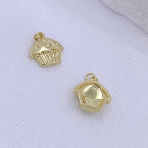 Detailansicht goldener Cupcake-Anhänger mit Punktrelief und runden Befestigungsringen