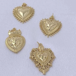 Set of four gold sacred heart pendants with crown and sunburst relief details