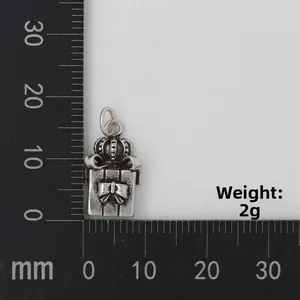 Vue macro d'un pendentif boîte cadeau vintage de 2g avec couronne sur une règle