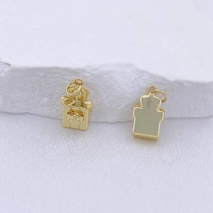 Détail du pendentif boîte cadeau dorée avec nœud et couronne, vues recto et verso