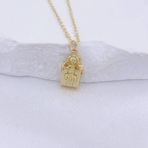 Collier doré avec pendentif boîte cadeau couronne sur fond blanc élégant