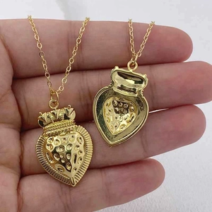 Macro shot of gold heart pendant with crown relief and hollow back design