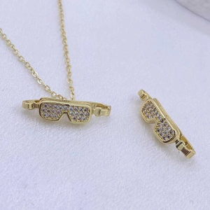 Detailansicht der Goldkette mit Brillenanhänger und fein gesetzten Zirkonsteinen
