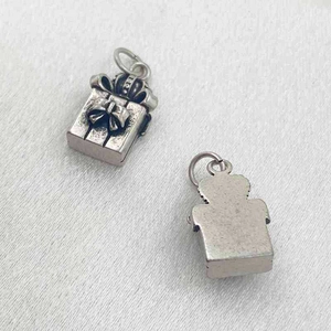 Vue détaillée de pendentifs boîte cadeau en argent avec un nœud élégant