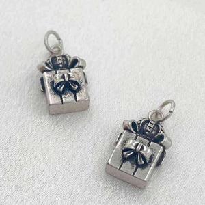 Macro d'un pendentif boîte cadeau argentée rétro avec détails de nœud et de couronne