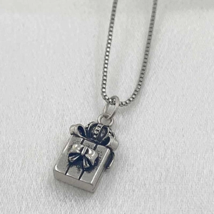 Gros plan détaillé du pendentif boîte cadeau en argent antique avec nœud sur satin