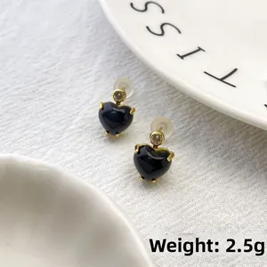 Detailed macro view of heart-shaped black stud earrings with zircon inlay, 2.5g weight