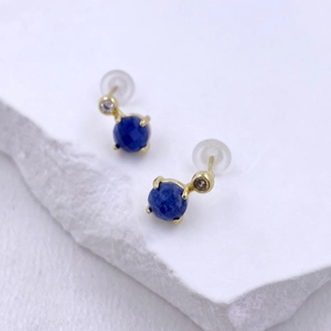 Close-up of heart-shaped blue zircon earrings with polished gold-plated metal finish