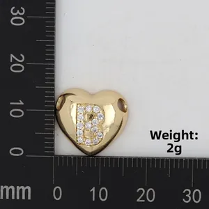 Detailed scale view of a gold heart pendant with letter B inlay and 2g weight mark