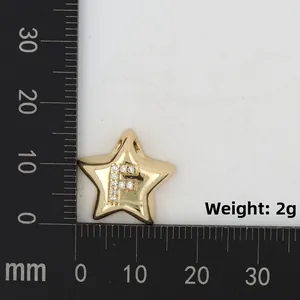 Makroaufnahme des Goldstern-Anhängers mit F-Zirkonia-Inlay auf einer Messskala