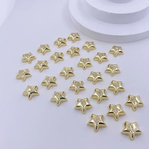 Makroaufnahme von goldenen Stern-Alphabet-Anhängern mit Kristallen für Schmuckdesign