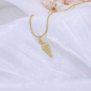 Makroaufnahme eines goldfarbenen Seeschneckenanhängers an einer feinen Goldkette