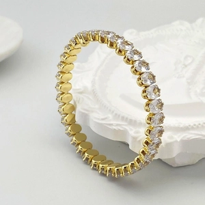 Vue macro du bracelet éternité doré avec zircons ronds sertis de griffes élégantes