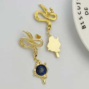 Detail of snake shaped gold earrings with blue enamel concentric circle charms