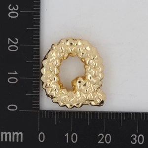 Detailansicht des goldenen Buchstaben Q Anhängers mit Sandstruktur und 20mm Skala