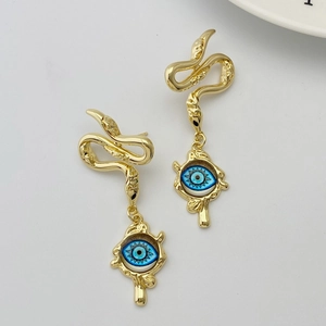 Close-up of golden snake earrings with blue evil eye charms on a clean white background