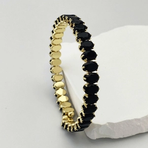 Détail du bracelet éternité avec pierres noires ovales et monture plaquée or