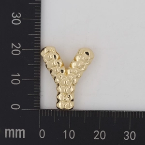 Detailansicht eines goldenen Buchstabens Y Anhängers mit Hammerschlag-Optik und Lineal