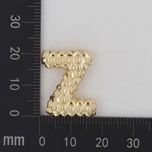 Detailansicht goldener Z-Anhänger mit Blasenstruktur, ca. 20 mm Höhe auf Maßstab
