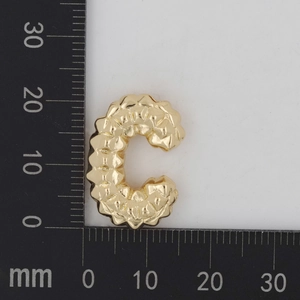Detailansicht eines goldenen C-Anhängers mit Textur und Größenvergleich in Millimetern