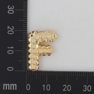 Makroaufnahme vom goldenen Buchstabe F Anhänger mit strukturierter Oberfläche und Maßen