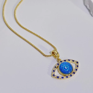 Vista macro del colgante de ojo turco dorado con mandala azul y circonitas