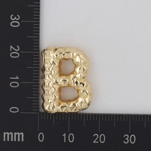 Detailansicht eines goldenen Buchstabe-B-Anhängers mit Felsstruktur und Größenangaben
