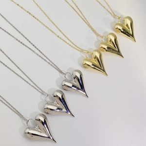 Detailed view of 18K gold and silver plated liquid heart pendants on thin link chains