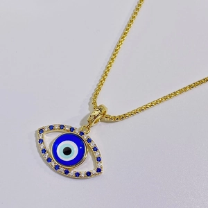 Primer plano de collar colgante de ojo turco chapado en oro con piedras azules y blancas