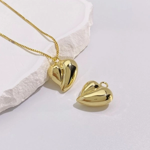 Detailed close-up of 18K gold-plated heart pendant with polished mirror finish and box chain